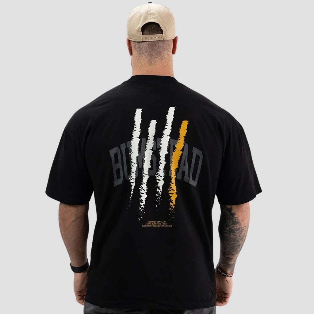 Homem com boné visto de costas usando a camiseta preta da coleção CBUM Bumstead da Iron Club.
