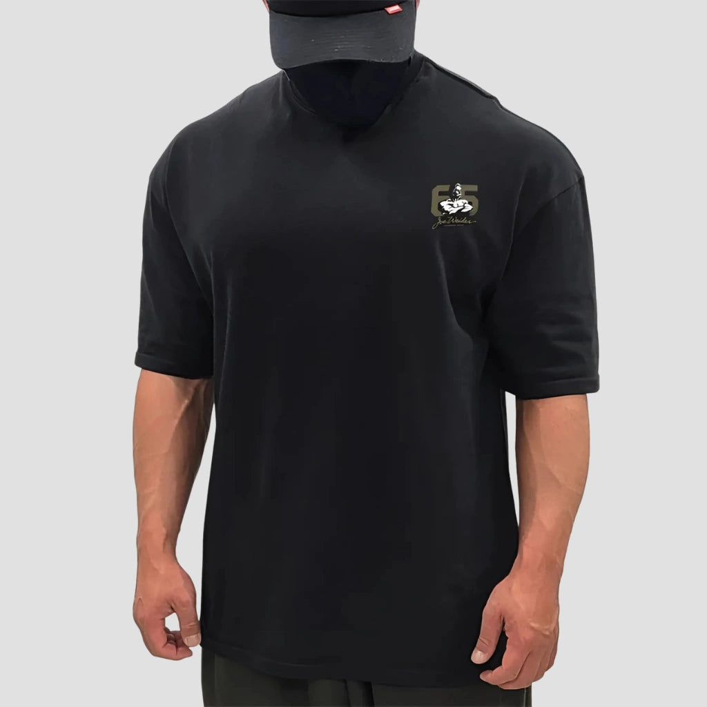 Modelo masculino vestindo a camiseta oversized preta da coleção Mr. Olympia Origins da Iron Club.