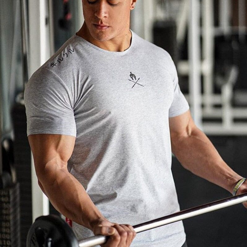 Atleta fazendo rosca na barra, usando a blusa spartan cinza