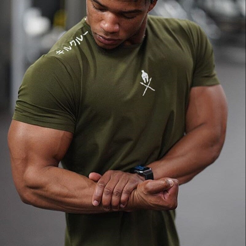 Close-up do caimento slim fit da camiseta Spartan verde no corpo de um atleta, destacando o peito e os braços.