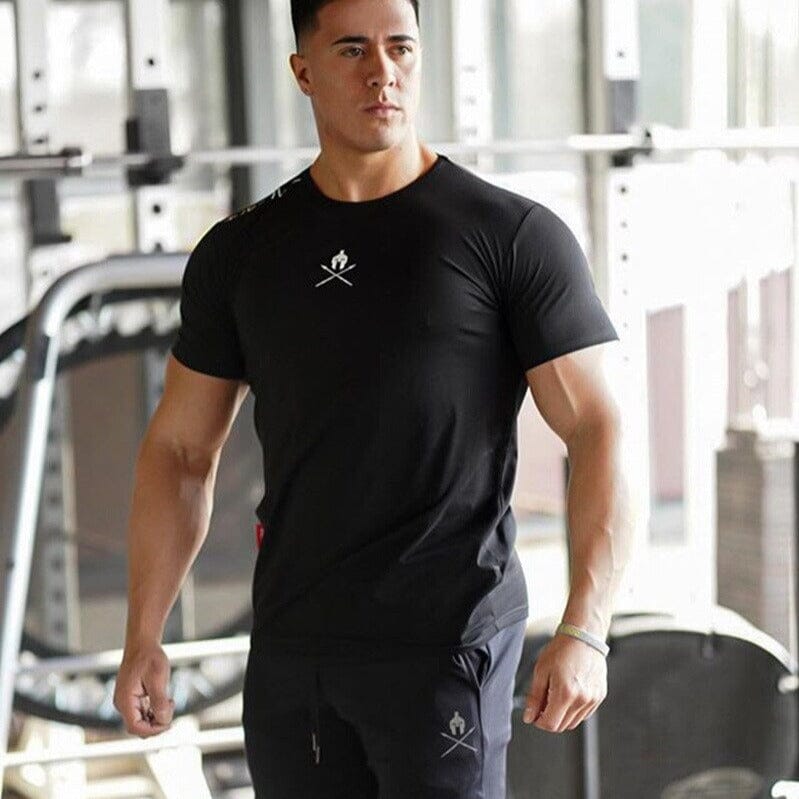 Atleta na academia vestindo o conjunto de treino Iron Club, com a camiseta preta Spartan em destaque.