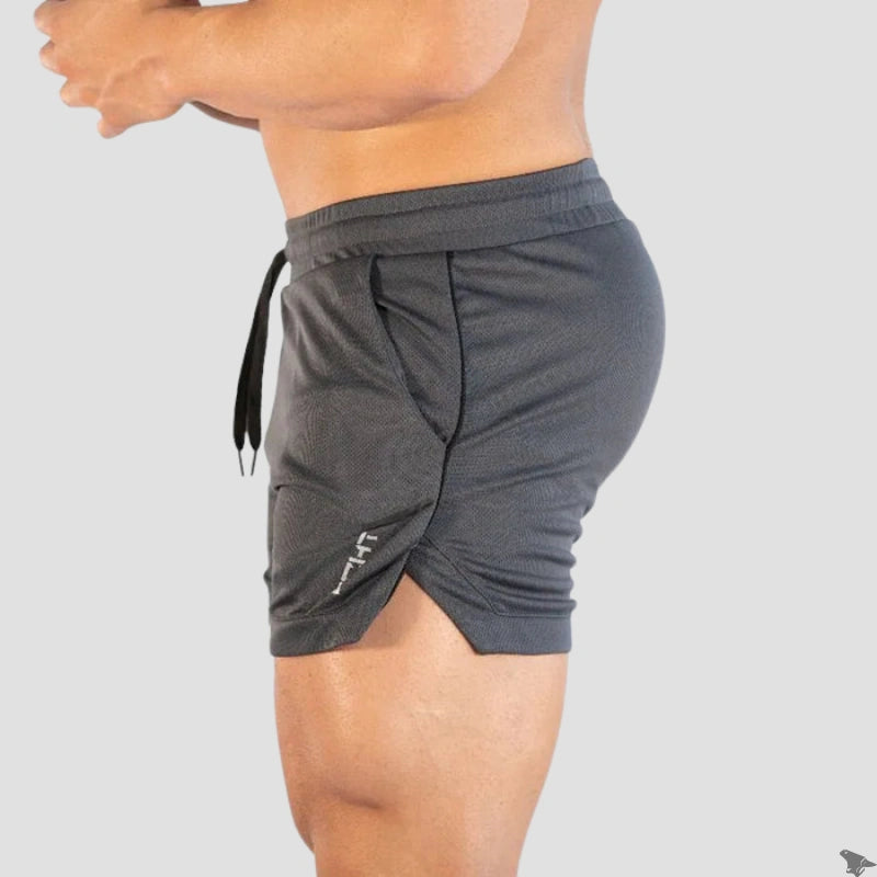 Perfil lateral do short de treino Echt na cor cinza, destacando o comprimento curto e a abertura lateral para maior mobilidade.
