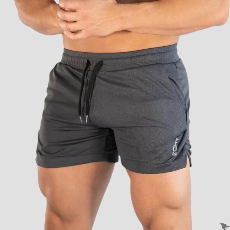 Vista frontal de um atleta usando o short de treino cinza da coleção Echt da Iron Club, mostrando o caimento slim e o design do bolso.